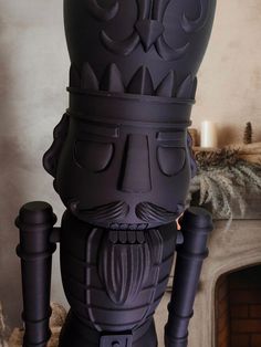 a black statue sitting on top of a table next to a fire place