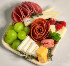 a platter filled with cheese, meat and fruit