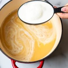 a person is stirring some liquid in a pot