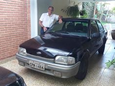 a man standing next to a black car