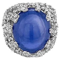 This cocktail ring features a 14.10 carat heated blue double Cabochon sapphire surrounded by 1.46 carat total weight of diamonds in a coral reef pattern. It is set in 18 karat white gold. This ring is a size 5 but can be resized upon request. Cocktail Ring Diamond, Coral Reef Pattern, Princess Diana Engagement Ring, Diana Engagement Ring, Blue Zircon Ring, Reef Pattern, Yellow Gold Cocktail Ring, Diamond Cocktail Ring, Gold Cocktail Ring