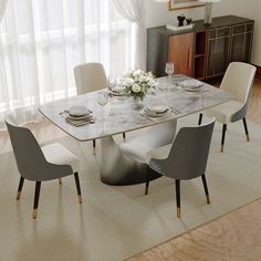 a dining room table with chairs and a vase on the top, in front of a window