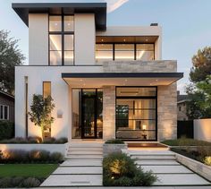 a modern house with stone steps leading up to the front door