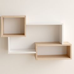 two empty wooden shelves against a white wall