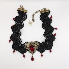 This vintage gothic styled crystal choker necklace features captivating Siam Red Swarovski crystals with nice crisp facets and brass embellishments. The detailed stampings have been in production since the 1940's and the vintage 16x11mm focal crystal is no longer in production, making this necklace a rare find. The lace is double-layered and hand sewn together for extra durability. Both elegant and stylish, this piece would be perfect for any formal occasion. Swarovski Crystals are made in Austr Vintage Red Choker For Party, Vintage Red Choker Jewelry, Red Vintage Choker Jewelry, Vintage Red Metal Choker, Gothic Crystal Jewelry For Gift, Victorian Metal Choker As Gift, Victorian Metal Choker For Gift, Victorian Metal Choker Gift, Lace Choker Necklace