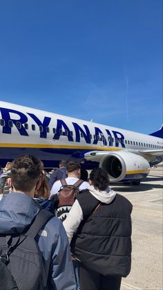 people are standing in line to get on an airplane