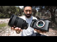 a man holding two cameras in his hands