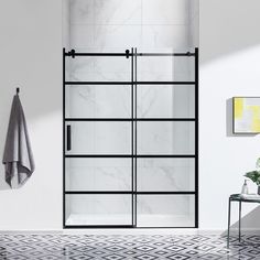 a bathroom with marble tile flooring and white walls, including a glass shower door