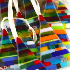 multicolored pieces of glass sitting on top of each other next to a bag