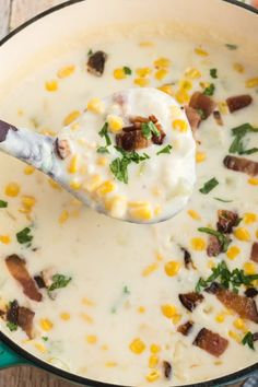 a spoon full of soup with corn and cheese