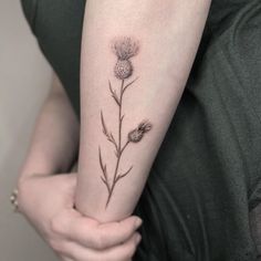 a woman's arm with a flower tattoo on the left side of her arm