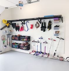 an organized garage with lots of tools and items on the wall, including umbrellas