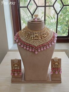 a necklace and earring set on display in front of a window