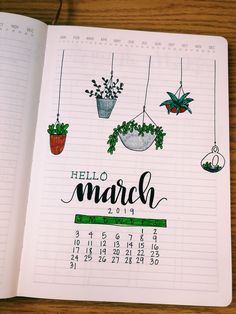 an open planner with plants hanging from it's sides and the words hello march written in cursive writing