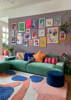 a living room filled with lots of furniture and pictures on the wall above it's couch