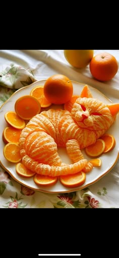 an orange cat made out of fruit on a plate