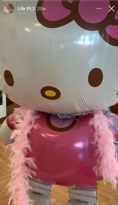 a large hello kitty balloon sitting on top of a wooden floor