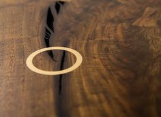 a close up of a wooden table with a ring on the edge and wood grained surface