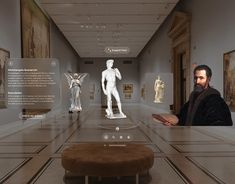 a man is looking at some statues in a museum