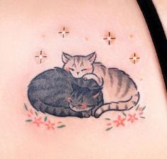 a woman with a tattoo on her stomach has two cats laying next to each other