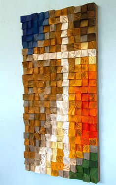 an art piece made out of wood with different colors on the wall and in front of it