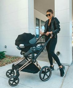 a woman pushing a stroller with a baby in it