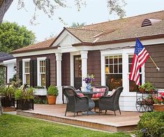 a patio with chairs, table and an american flag on the back wall in front of it