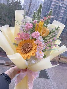 a person holding a bouquet of flowers in front of a window with the city skyline behind them