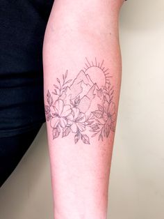 a woman's arm with flowers and mountains tattoo on the left side of her body