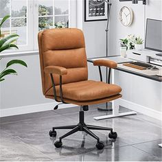 a brown office chair sitting in front of a computer desk with a clock on the wall