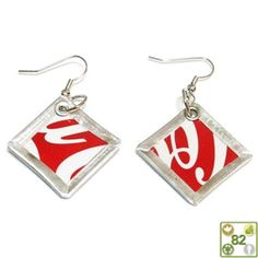 two red and white square shaped earrings with the letter s in it's center