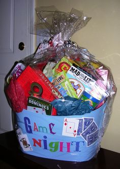 a basket filled with games and toys on top of a wooden table next to a door