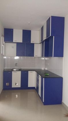 an empty kitchen with blue and white cabinets