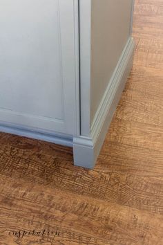 an image of a kitchen with wood flooring and blue cabinetry on the wall