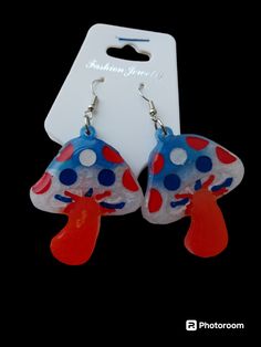 These are red white and blue  mushroom earrings they are detailed with matching red white blue acrylic paint then clear coated to seal the pretti3s forever ❤️🤍💙 we also do custom creations just message me anytime for more information😊 Cute White Earrings With Mushroom Design, Patriotic Blue Earrings For Gift, White Mushroom Design Drop Earrings, Whimsical Dangle Earrings With Mushroom Design, Handmade Blue Patriotic Earrings, Fun Style Red Resin Earrings, Fun Red Resin Earrings, Cute Mushroom-shaped Earrings For Gifts, Whimsical Mushroom-shaped Earrings For Gifts