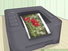 a printer that is printing pictures on the screen with it's lid open and red flowers