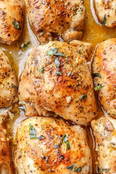 closeup of chicken thighs in a pan with garlic and herbs on top, ready to be cooked