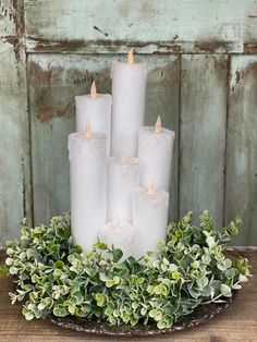 a group of white candles sitting on top of a wooden table