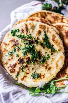 three flat breads with herbs on top