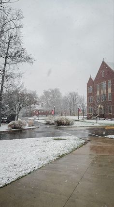 a snow covered street next to a red traffic light in the middle of winter time