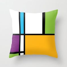 a colorful pillow with black, yellow, green and blue squares on the front side