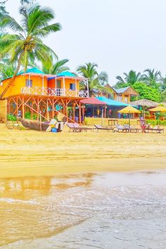 the beach is lined with colorful houses and umbrellas