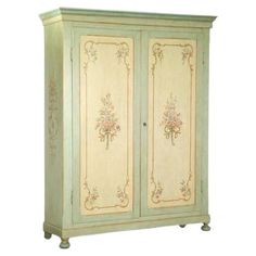 an antique armoire with floral designs painted on the front and sides, in light green