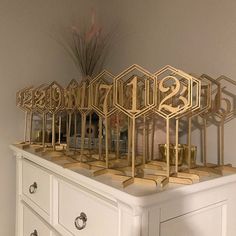 a white dresser topped with lots of gold trophies