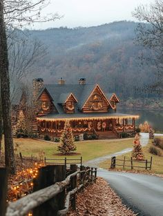 a large log cabin with christmas lights on the front and side of it's roof