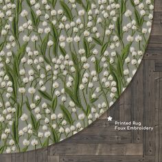 the fabric has white flowers and green leaves on it, along with wood flooring