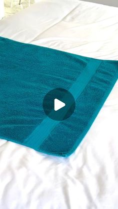 a blue towel is laying on top of a white bed with the word youtube written across it