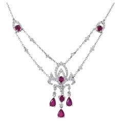 Presenting our stunning 18KT White Gold Genuine Ruby and Diamond Drop Necklace, a masterpiece of elegance and sophistication. This exquisite necklace showcases the beauty of genuine Burmese rubies, featuring a total of 2.25 carats of pear and oval-cut rubies. These radiant gemstones are beautifully complemented by 1.26 carats of round-cut diamonds, which boast G color and VS1-VS2 clarity. The result is a truly captivating piece of jewelry that exudes luxury and grace. Length 17 inches. Weight 9. Luxury Ruby Necklace With Brilliant Cut, Formal Ruby Diamond Necklace With Brilliant Cut, Luxury Ruby Bridal Necklace, Fine Jewelry Ruby Diamond Necklace Brilliant Cut, Luxury Ruby Necklace With Diamond Accents, Luxury Ruby Necklaces With Diamond Accents, Luxury Ruby Diamond Necklace With Accents, Luxury Ruby Diamond Necklace With Diamond Accents, Elegant White Gold Ruby Necklace