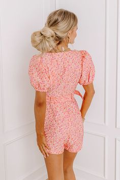 - Blossoming beauty has arrived with this darling floral jacquard romper! With delicate blooms, its puff sleeves add a touch of whimsy while the flattering belted waistline accentuates your curves with a sprinkle of charm. Perfect for picnics in the park or strolls through sun-kissed gardens, this romper radiates sweetness and bubbly flair, making every moment feel like a delightful adventure in full bloom. - Unlined floral jacquard material featuring pink and orange hues - A square cut neckline Pink Floral Print Jumpsuits For Garden Party, Pink Floral Print Jumpsuits And Rompers For Garden Party, Pink Floral Print Jumpsuits And Rompers With Short Sleeves, Pink Floral Print Short Sleeve Jumpsuit, Pink Floral Print Short Sleeve Jumpsuits And Rompers, Feminine Fitted Floral Jumpsuits And Rompers, Floral Print Short Sleeve Jumpsuits And Rompers For Brunch, Orange Hues, Picnic In The Park