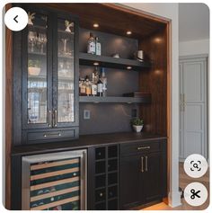 a wine cooler in the corner of a room with shelves full of bottles and glasses